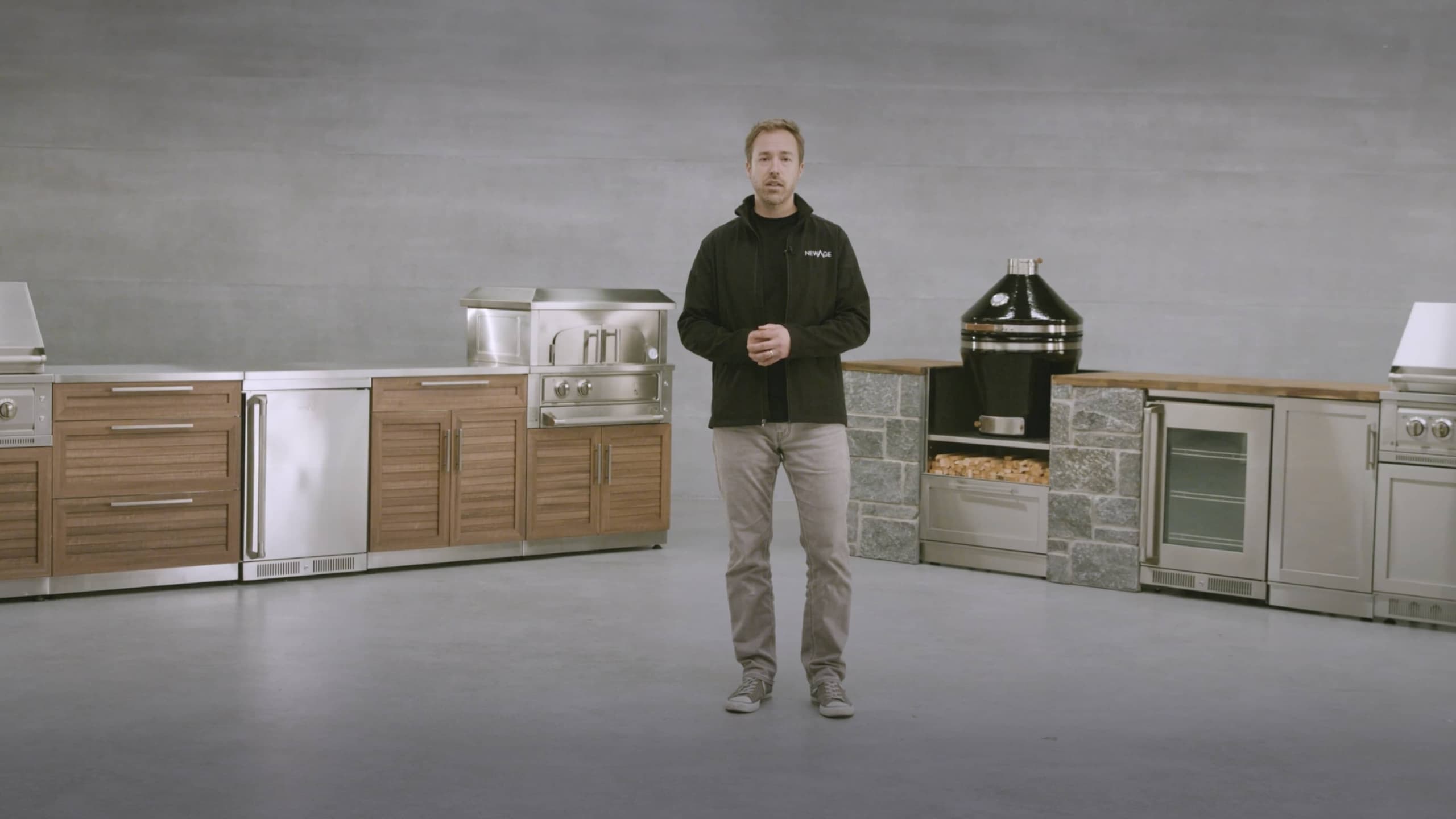 NewAge product specialist in a showroom of outdoor kitchen cabinets, pizza oven and kamado grill
