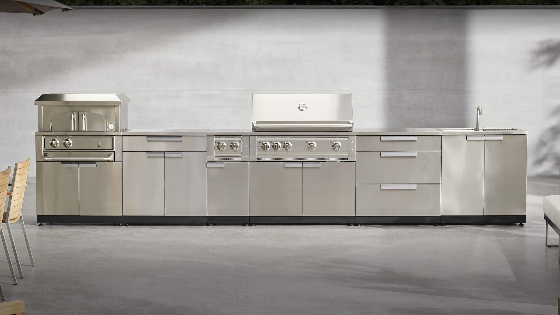 L-shaped NewAge outdoor kitchen with a grill, sink and refrigerator cabinet