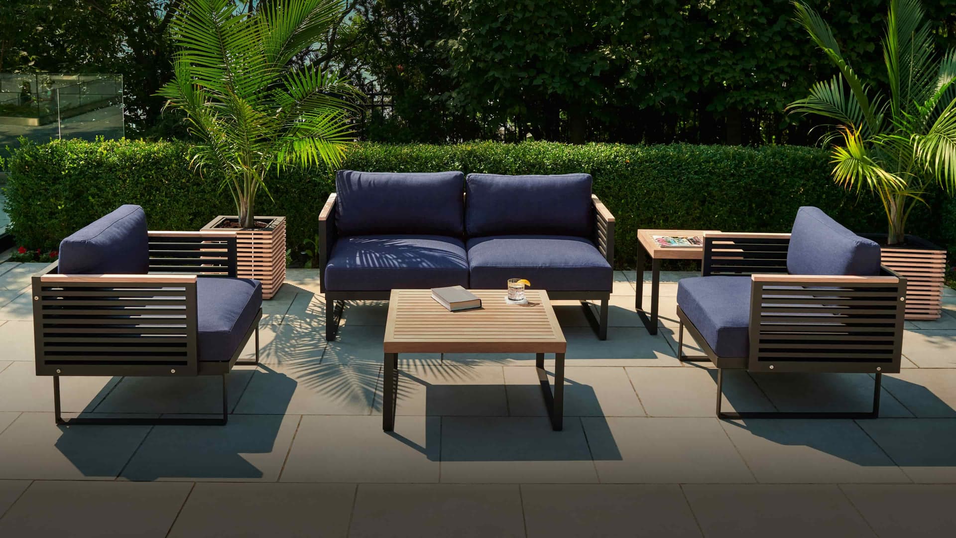 NewAge outdoor sectional, loungers and planters arranged on a patio