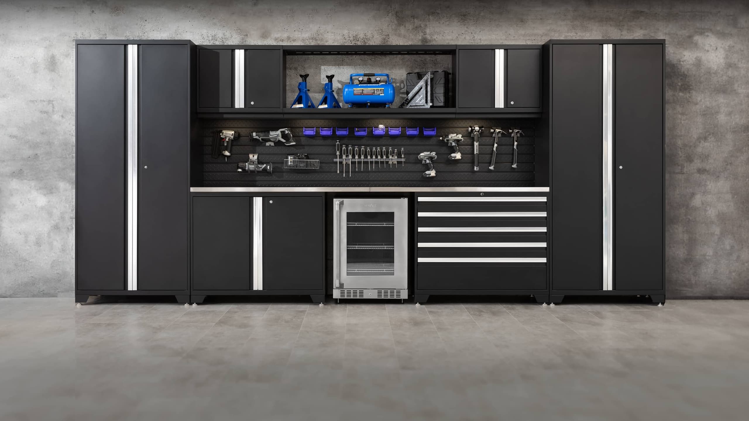 NewAge grey garage cabinets with a stainless-top workbench and an overhead tire rack